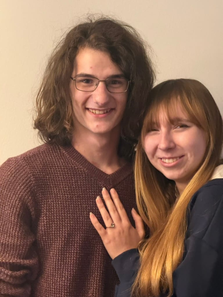 Brooke and William smiling together, Brooke showing her engagement ring